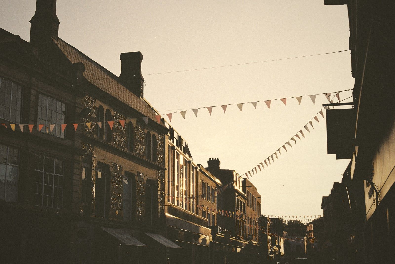 A shopping street with bunting in the evening sun