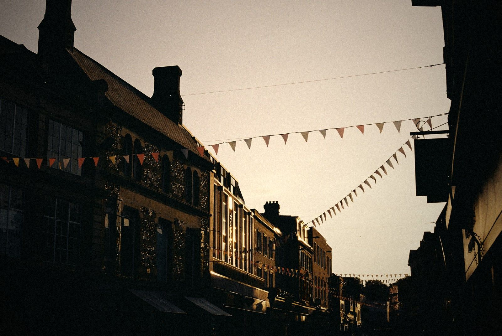 A shopping street with bunting in the evening sun