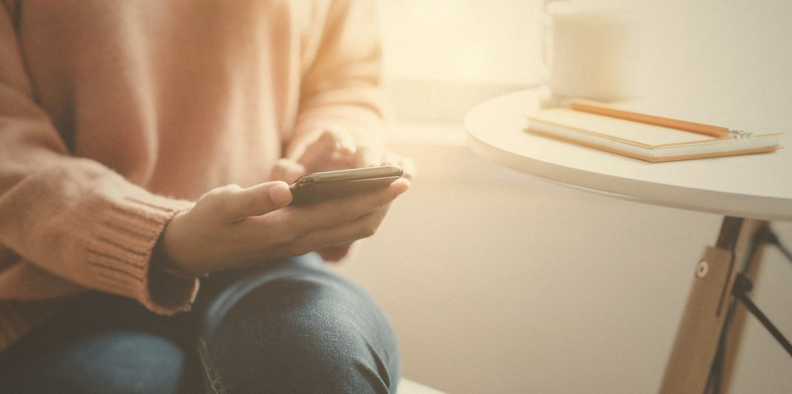 Hands holding a phone in soft window light